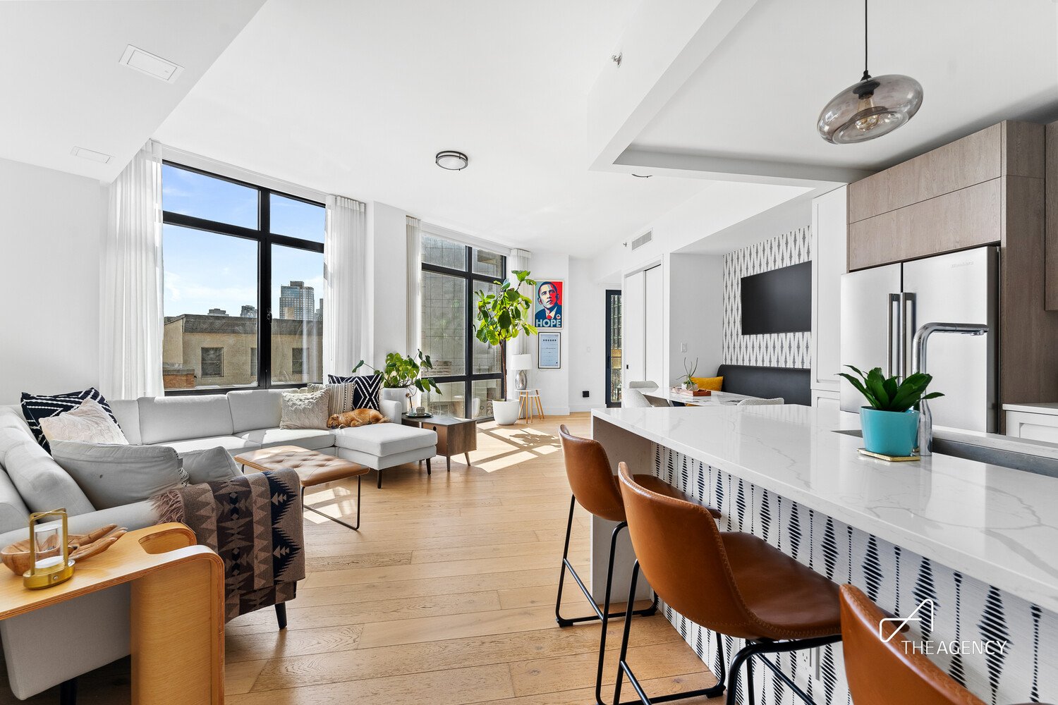 Open living room and kitchen with an island and bar stools at 10-64 Jackson Avenue 2A