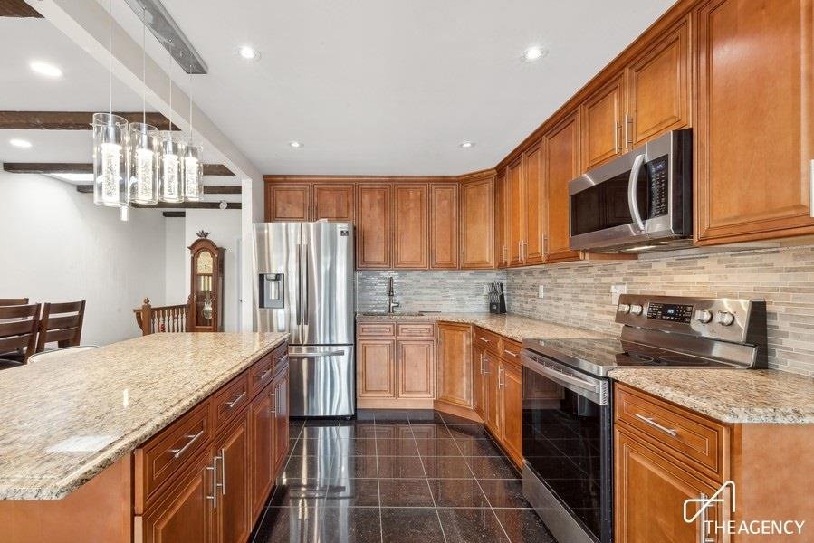 Kitchen with wood cabinets and an island at 164-38 95th Street