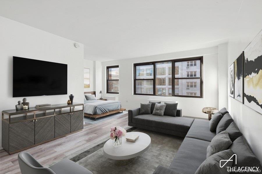 Living area with a sofa and a bed alcove at 200 E 27th Street 9-E