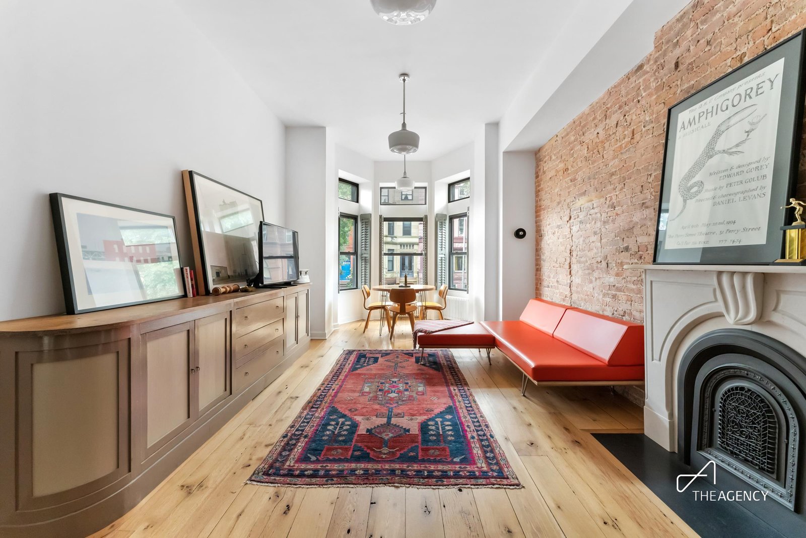 Long room with an exposed brick wall and a fireplace at 579 Jefferson Avenue 2
